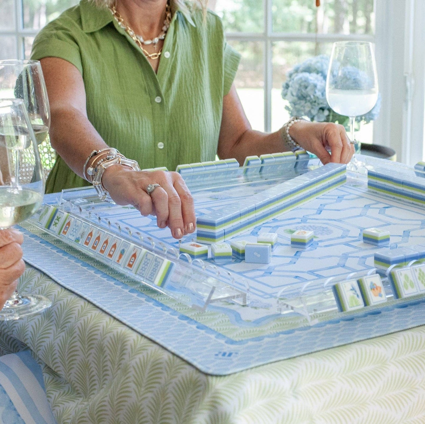 The House of Hydrangea mahjong tile set in play — blue and white floral tiles on racks with the hydrangea mat