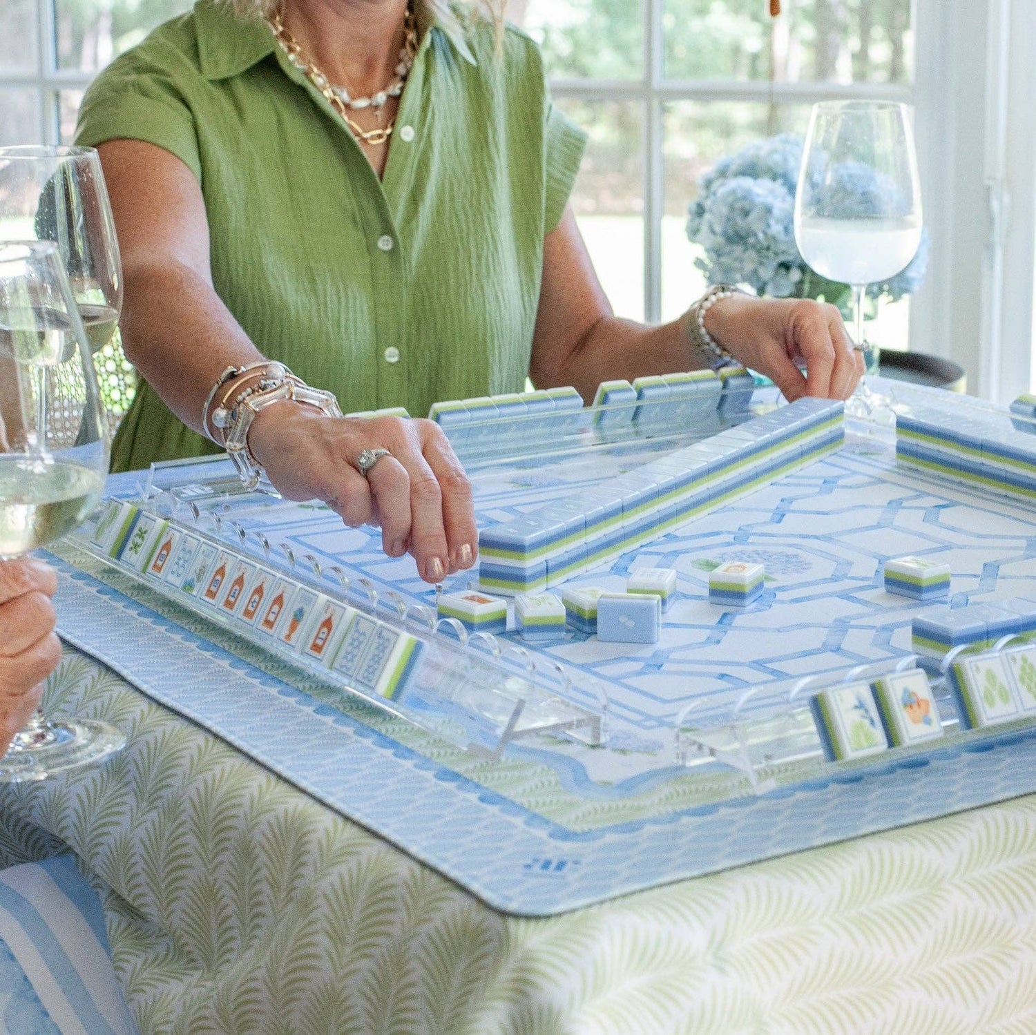 The House of Hydrangea mahjong tile set in play — blue and white floral tiles on racks with the hydrangea mat