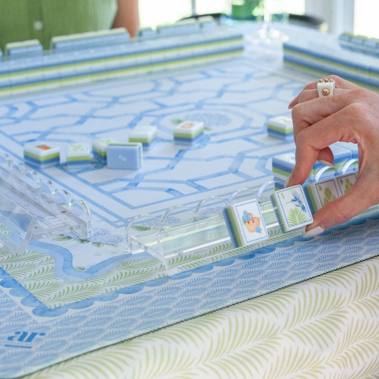 Close-up of a House of Hydrangea mahjong tile being placed on a rack during play