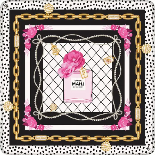 Eau de Mahj mahjong mat with pink perfume bottle, pearls, roses, gold chains and black-and-white polka dot border