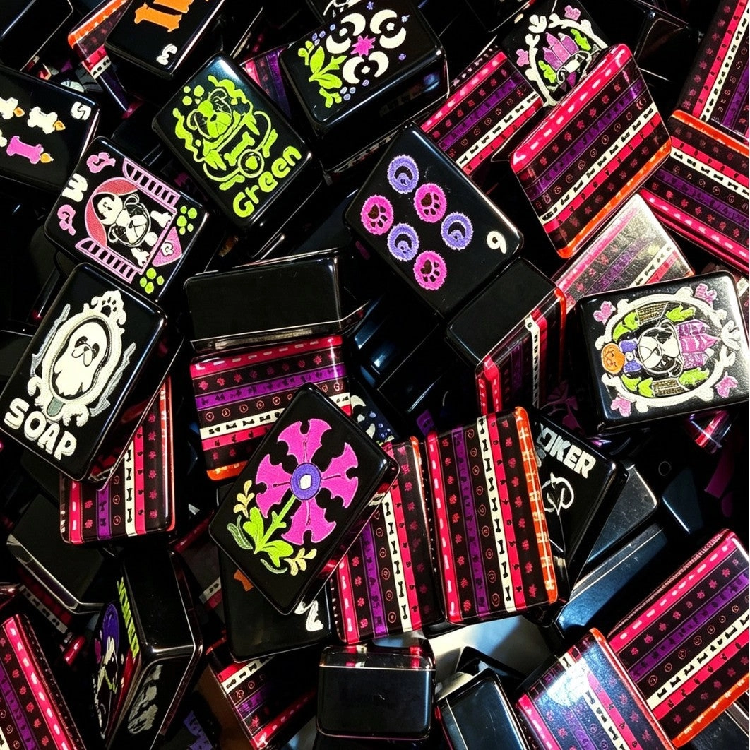 Pile of Spooky Halloween mahjong tiles — black tiles with pink striped backs, skulls, and Halloween faces