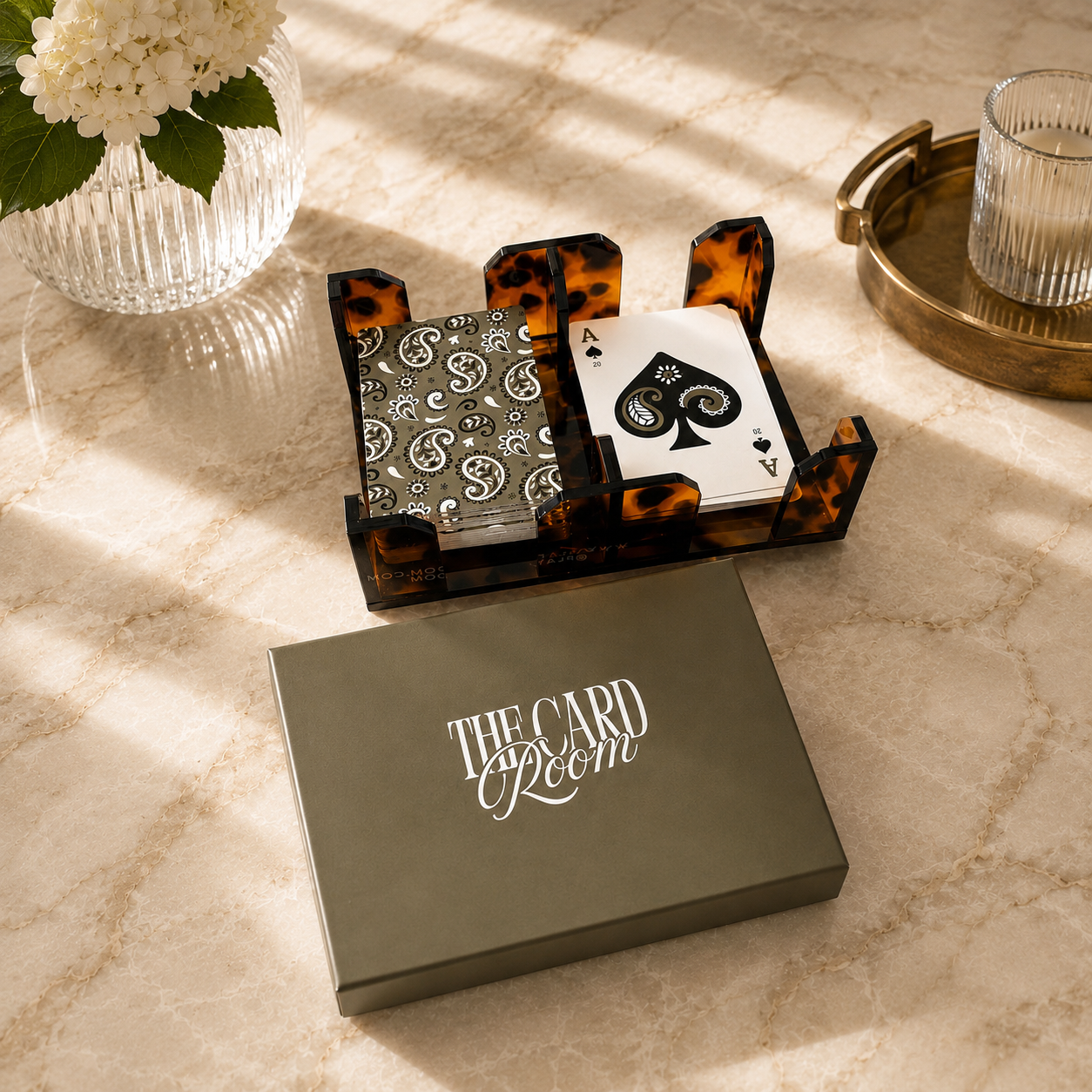Tortoise canasta card spinner with cards and gift box on marble