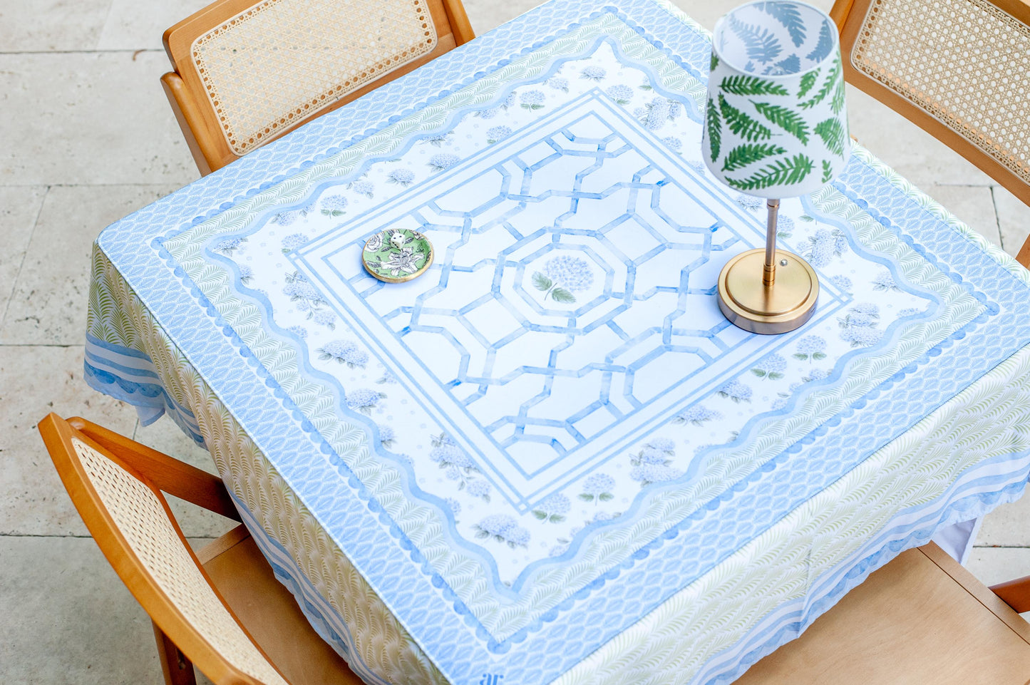 The House of Hydrangea Mahjong Mat on an outdoor game table — blue lattice and hydrangea mahjong mat