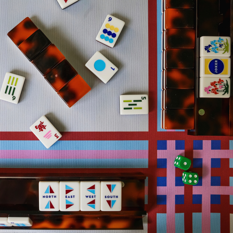 Tortoise Mod mahjong tiles in play on a tortoise rack with striped mat